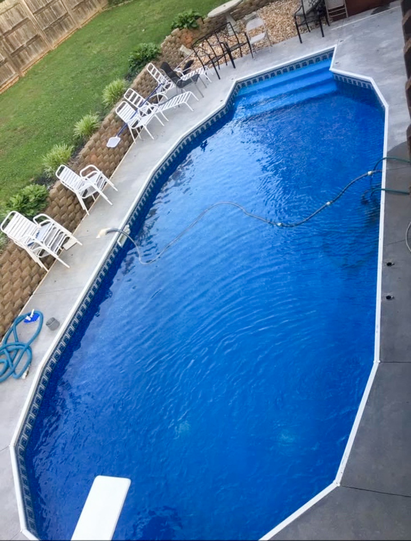Outdoor in‑ground pool with bright blue water, surrounded by concrete decking, lounge chairs, and a small grassy area at the home of Sponsored Residential Providers Anthony Barnes and Demita Taylor in Forest, Virginia.