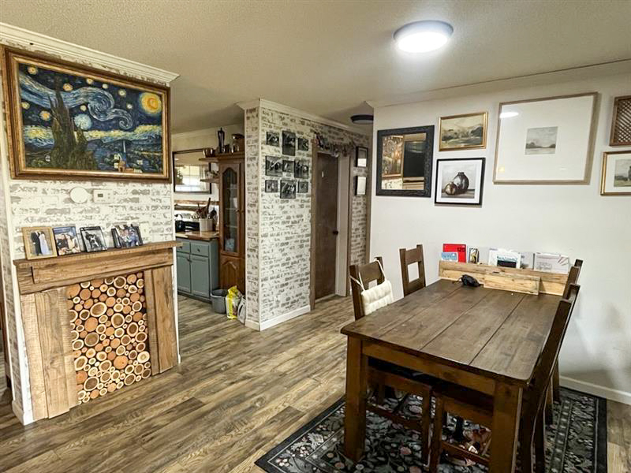 Dining room with wooden table and chairs, framed artwork on the walls, and wood flooring inside the home of Sponsored Residential Provider Kristen Bowers in Galax, Virginia.