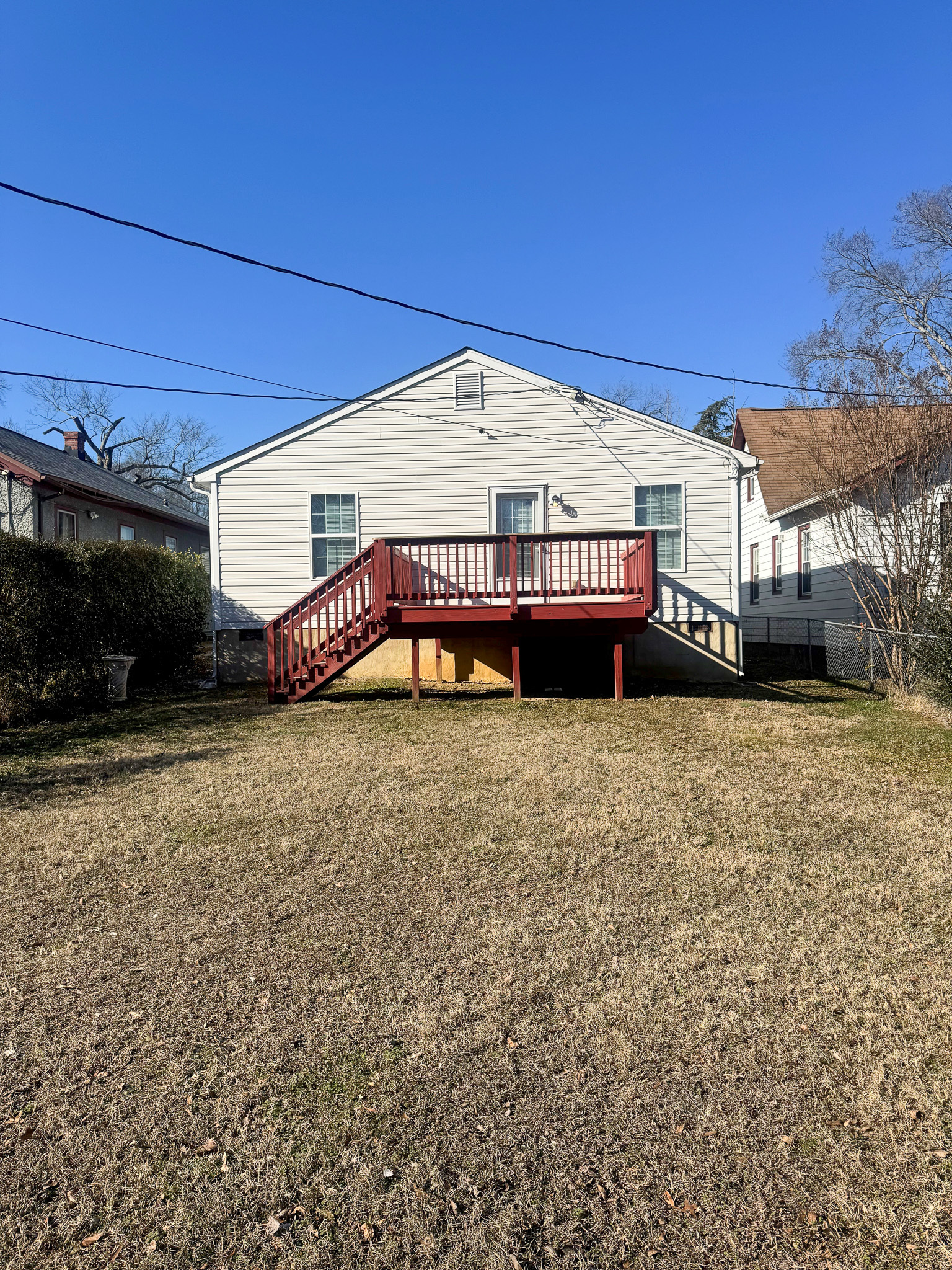 A white single‑story house with a raised red wooden deck overlooking a large backyard belonging to Sponsored Residential Providers Xaiver Heath and David Williams in Richmond, Virginia.