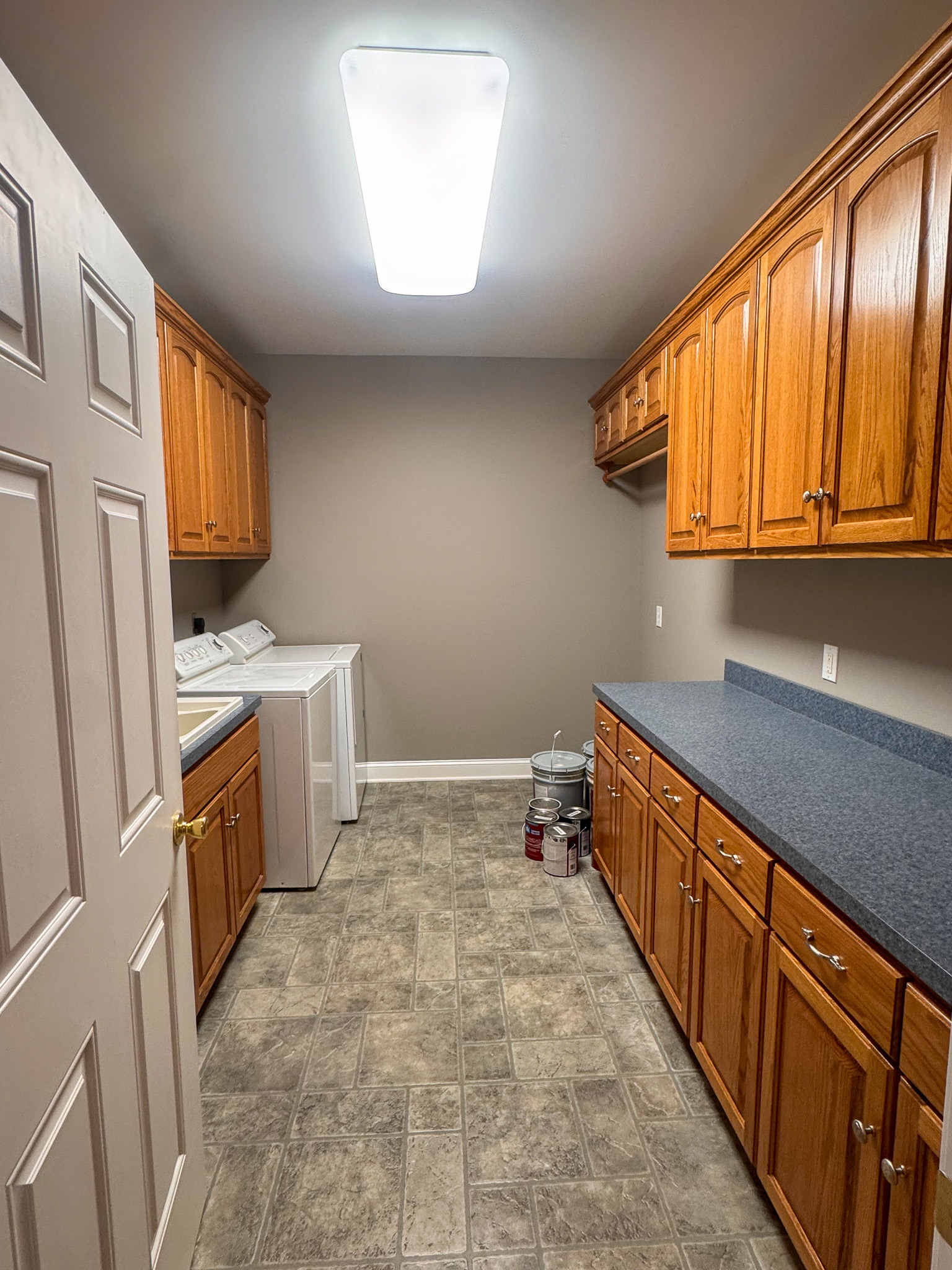 Laundry room with washer, dryer, wood cabinets, and countertop workspace inside the home of Sponsored Residential Provider Clayton Lawson in Amherst, Virginia.