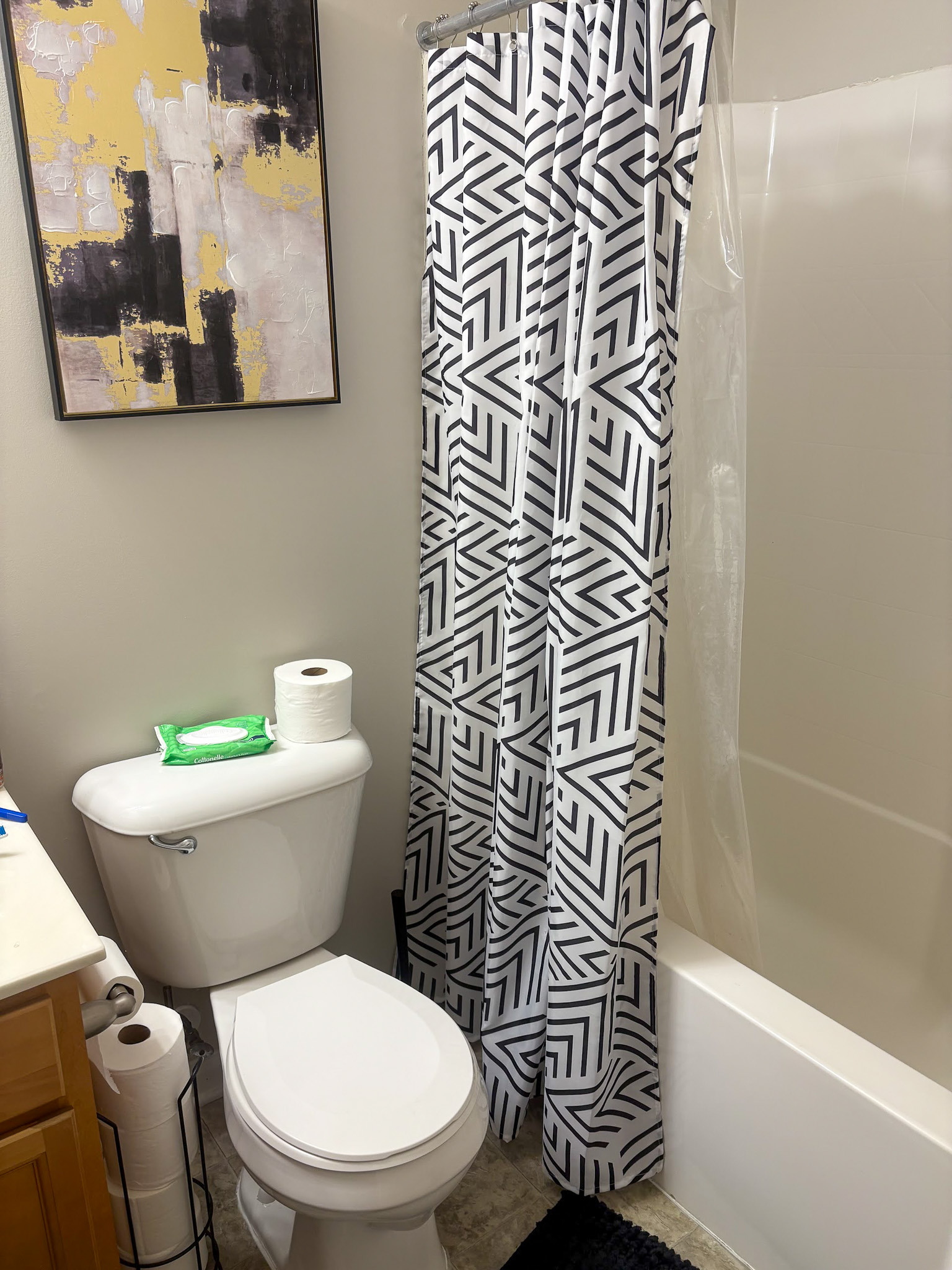 Bathroom with a shower, toilet, and abstract wall art inside the home of Sponsored Residential provider Cynthia Kimbrough-Mabry in Chester, Virginia