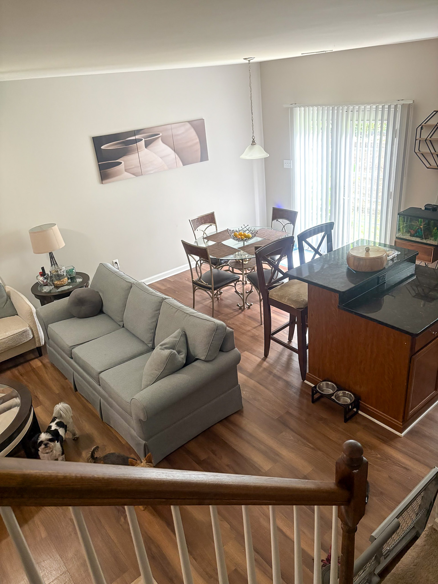 Open living and dining area with sofa, dining table, and large window with vertical blinds inside the home of Sponsored Residential provider Cynthia Kimbrough-Mabry in Chester, Virginia
