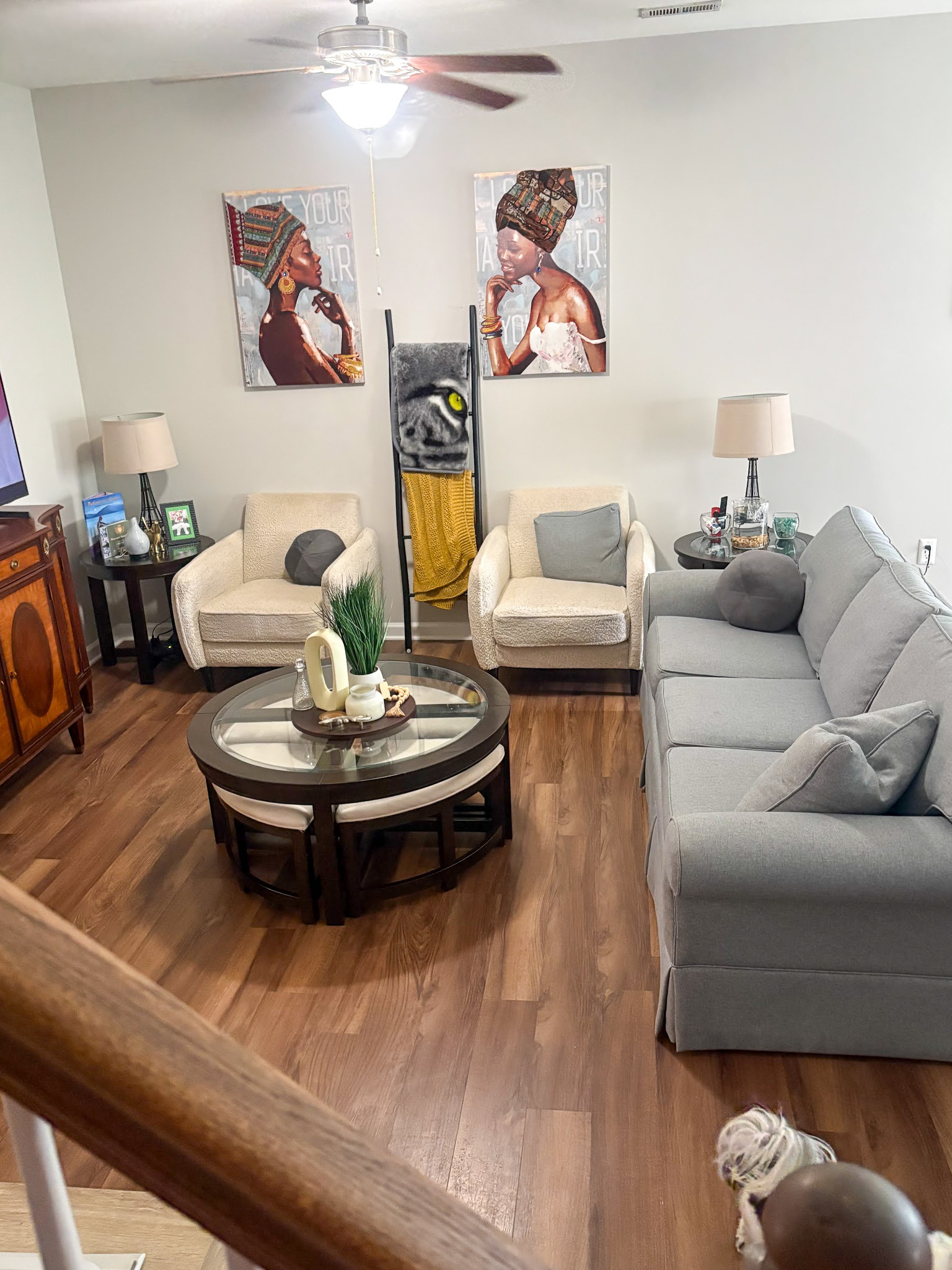 Open living room with sofa, chairs, and coffee table, featuring decorative wall art and a ceiling fan inside the home of Sponsored Residential provider Cynthia Kimbrough-Mabry in Chester, Virginia