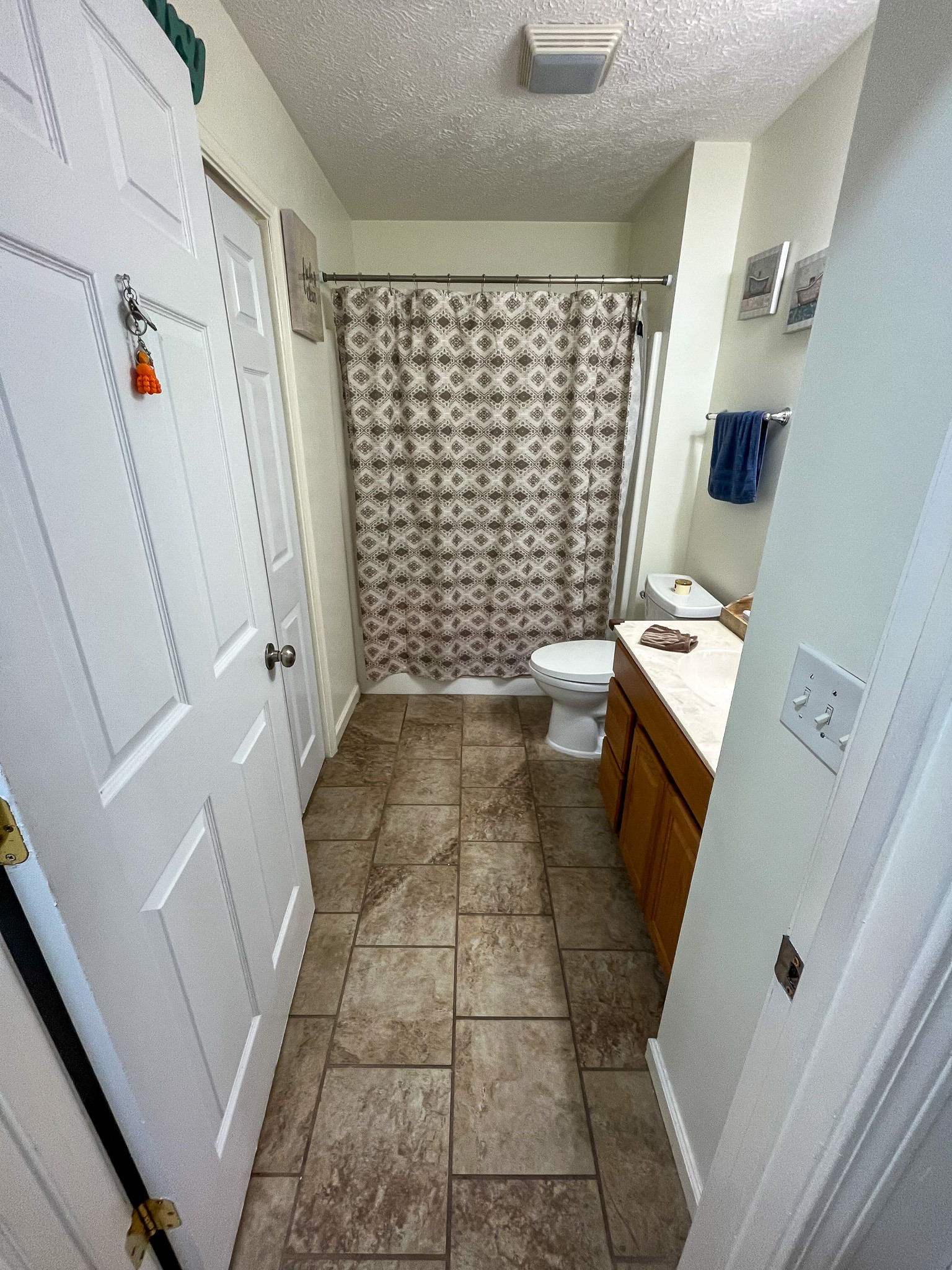 Full bathroom featuring a walk-in shower with curtain, vanity, and tile flooring. This is the home of Sponsored Residential Provider Delmy Sexton in Woodlawn, VA.