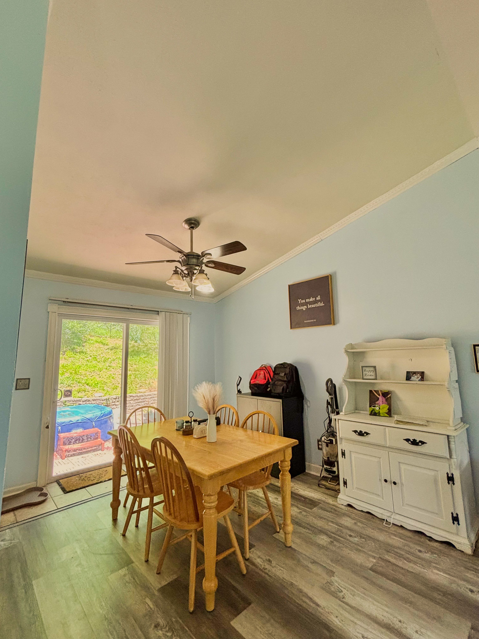 Dining room with wooden table and chairs, ceiling fan, sliding glass door, and wood‑look flooring inside the home of Sponsored Residential Provider Lana Cyzicks in Staunton, Virginia.