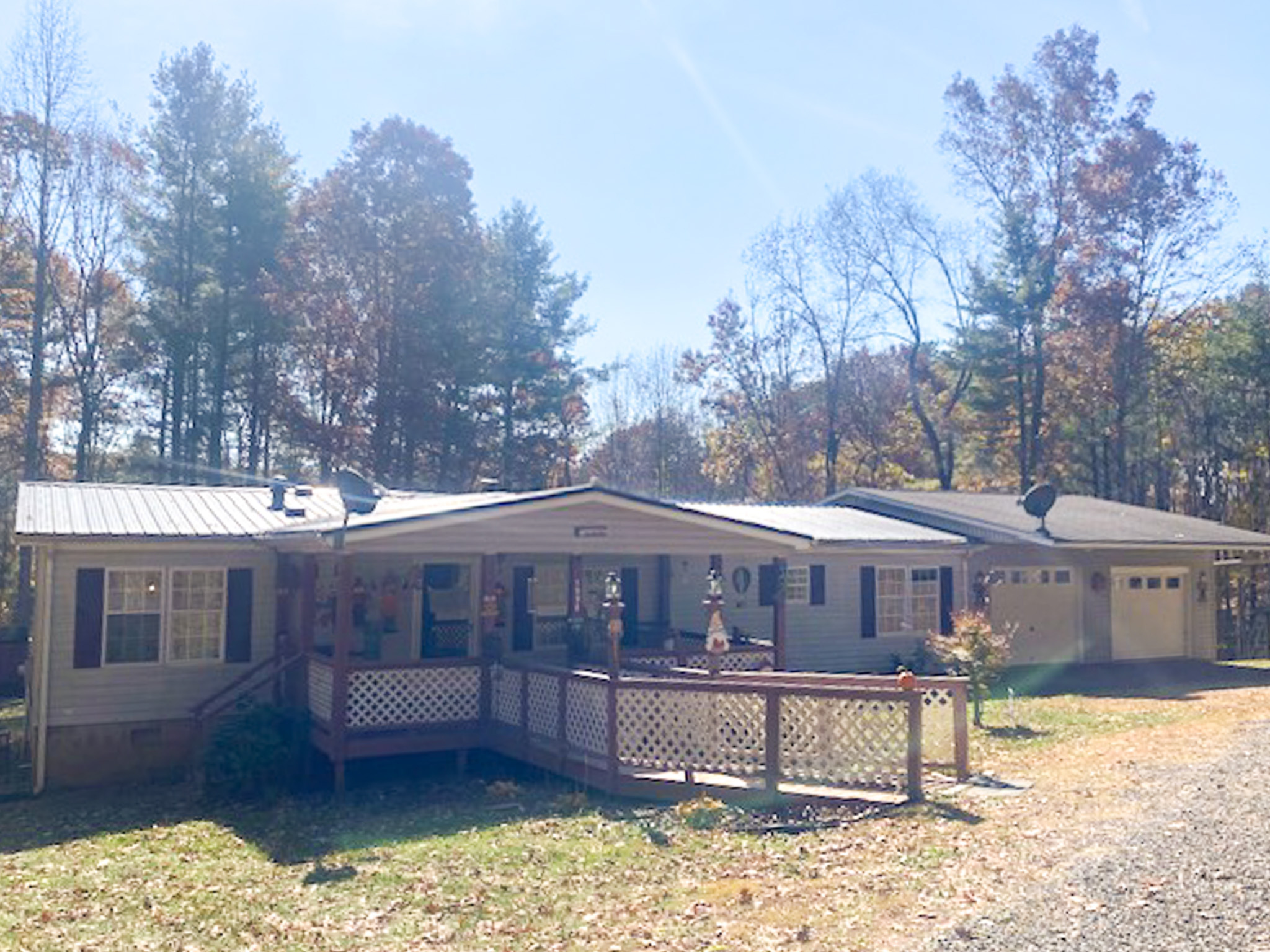 Ramp leads to a single‑story home with a covered front porch and railing, attached garage, and trees in the background belonging to Sponsored Residential Provider Angel Dixon in Woodlawn, Virginia.