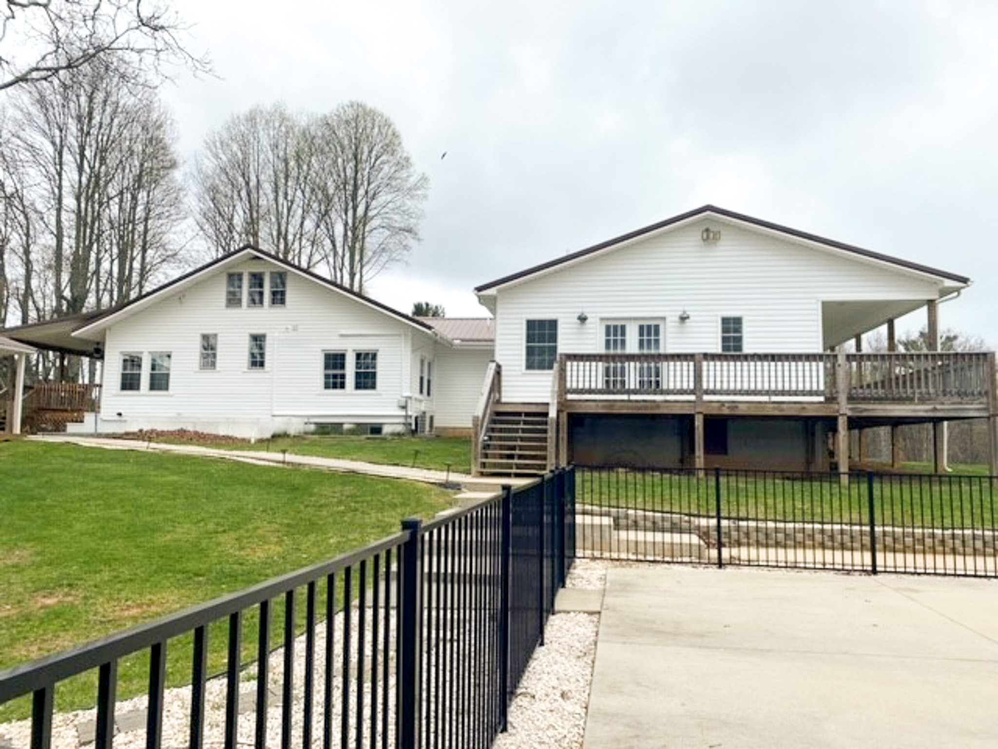 Rear view of Jake and Angie Beamer’s provider group home in Hillsville, Virginia, showing a large deck, accessible walkway, and fenced outdoor area.