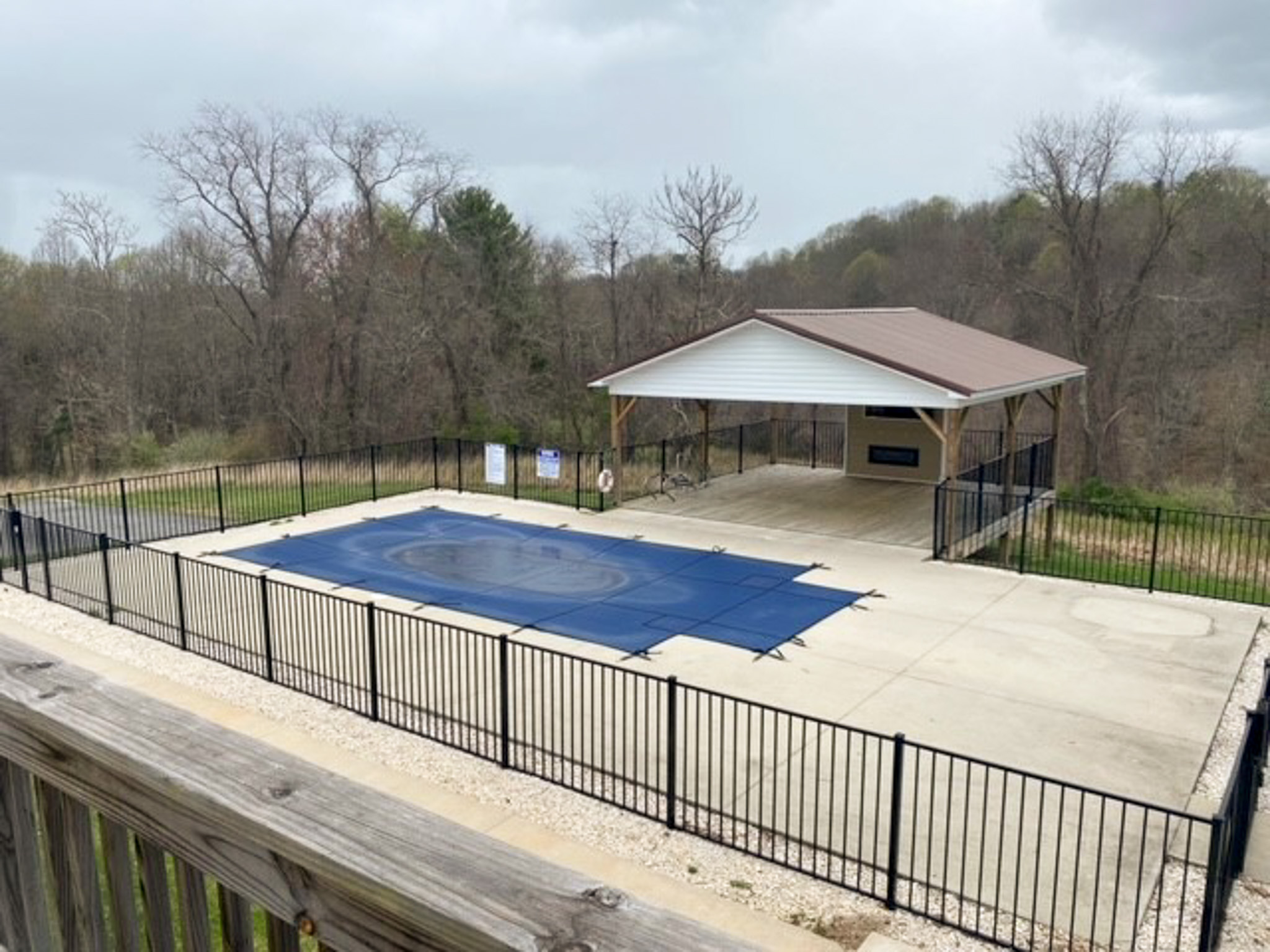 Fenced outdoor recreation area at Jake and Angie Beamer’s provider group home in Hillsville, Virginia, featuring a covered pavilion and pool area with a safety cover.