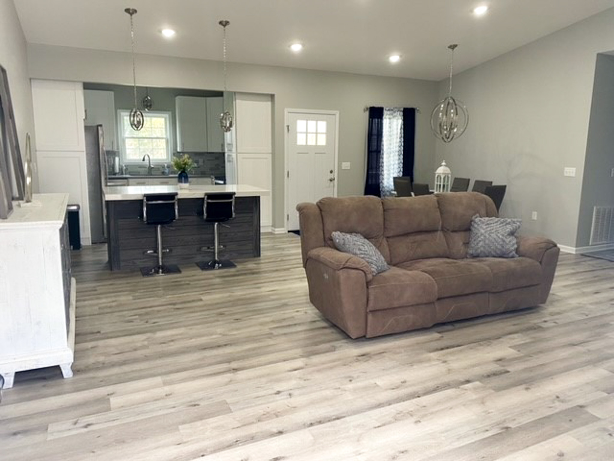 Modern kitchen and living space at Jake and Angie Beamer’s provider group home in Hillsville, Virginia, featuring an open floor plan, island seating, dining area, and comfortable gathering spaces.