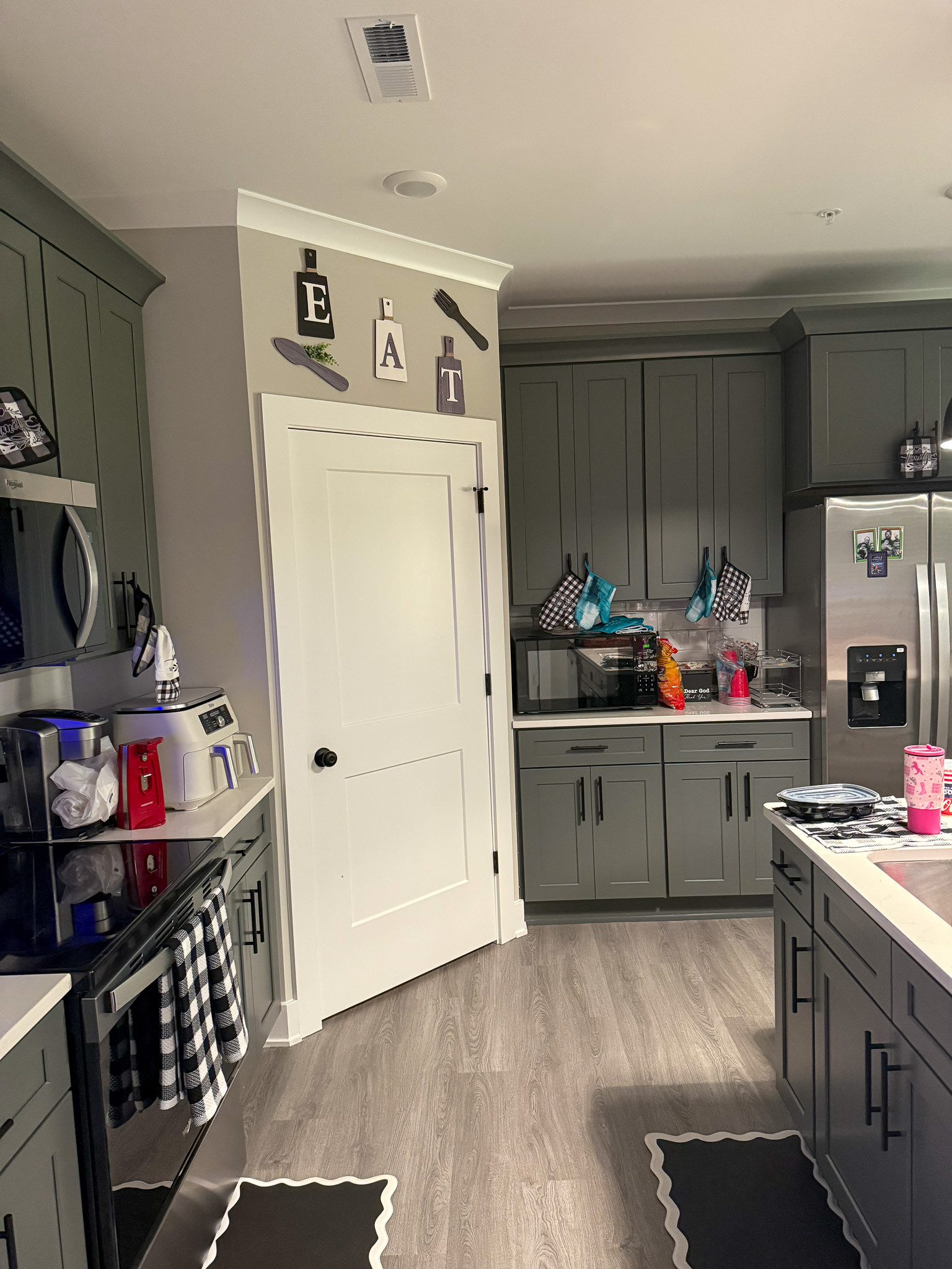 Modern kitchen with gray cabinetry, stainless steel appliances, and an island in the home of Sponsored Residential Provider Justina Megginson in Roanoke, Virginia.