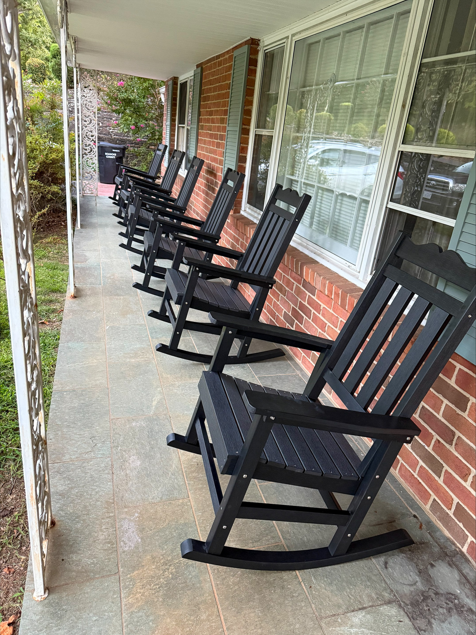 A row of black rocking chairs on the covered front porch at the home of Group Home Provider Tina Langhorn in Roanoke, Virginia.