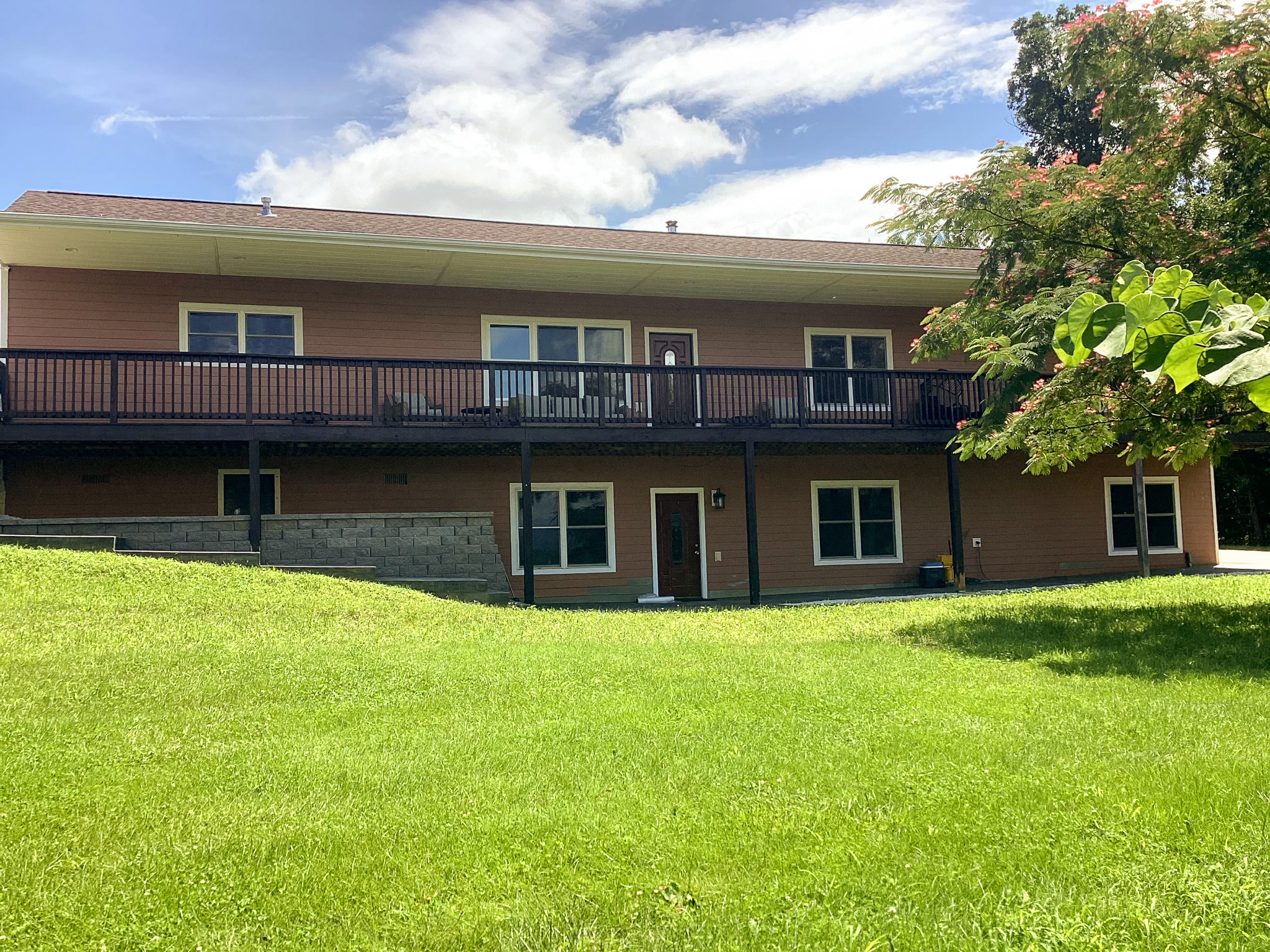 Two-story home with an elevated deck, spacious lawn, and mature trees in a peaceful setting. This home belongs to Wall Group Home provider Lisa Lohr in Harrisonburg, VA.