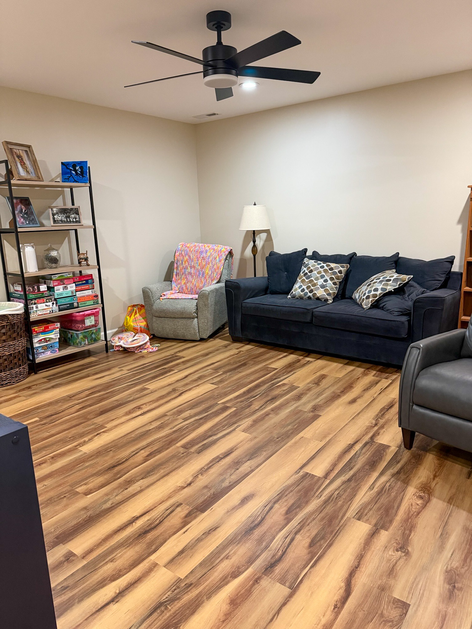 Comfortable gathering space with seating, shelving, games, and wood flooring in the home of Wall Group Home provider Lisa Lohr in Harrisonburg, VA.