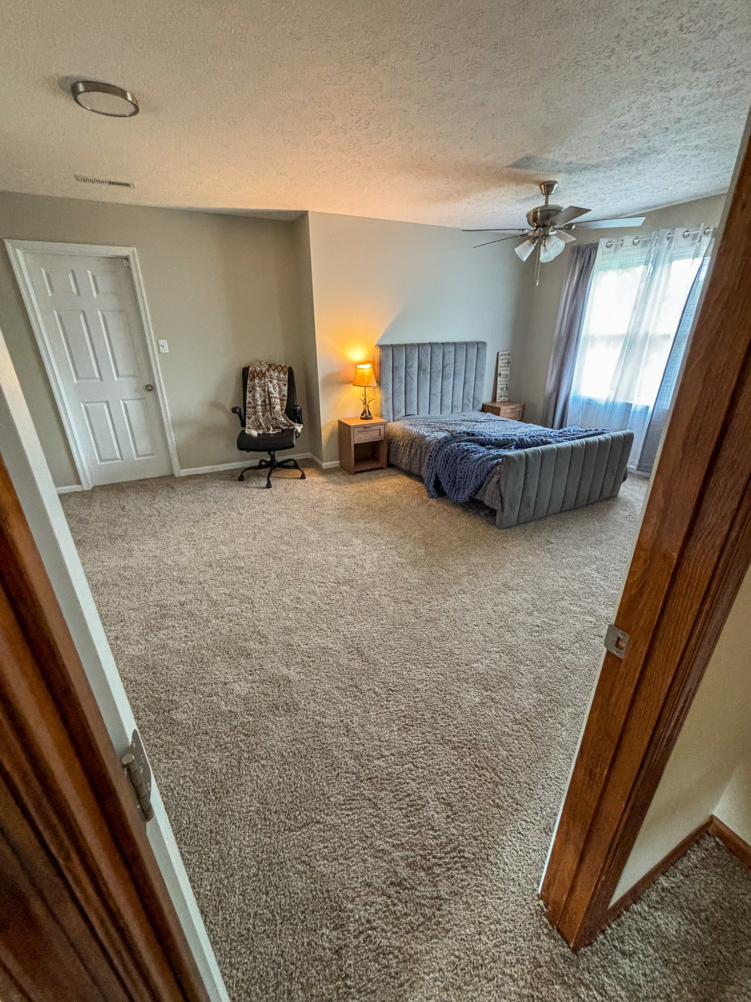 Bright and spacious bedroom with large windows, carpeting, and room for personalized furnishings in the home of Sponsored Residential Provider Mary Salvia in Lynchburg, Virginia.
