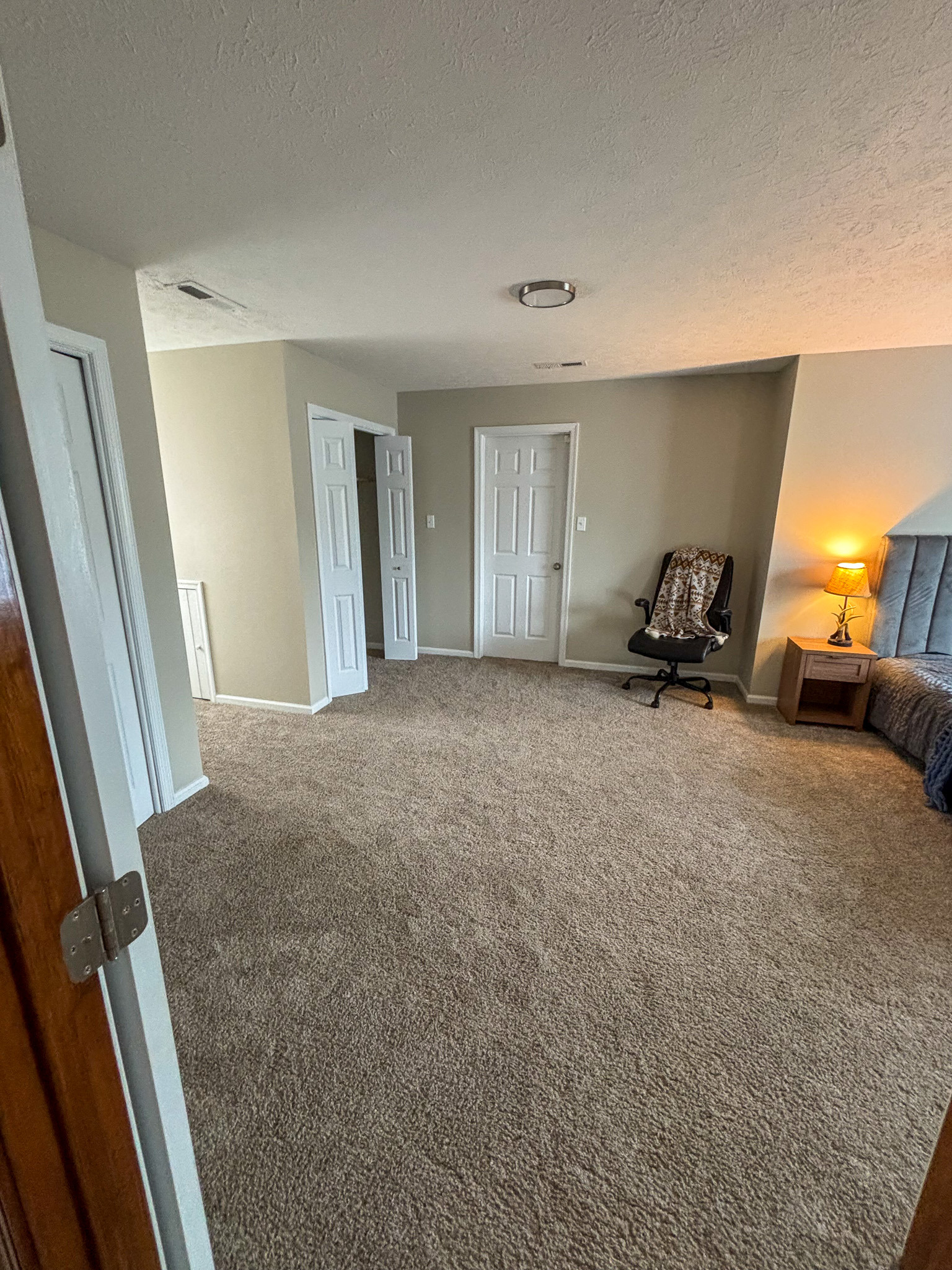 Spacious carpeted bedroom with ample room for a personal sitting area and additional storage, located in the home of Sponsored Residential Provider Mary Salvia in Lynchburg, Virginia.