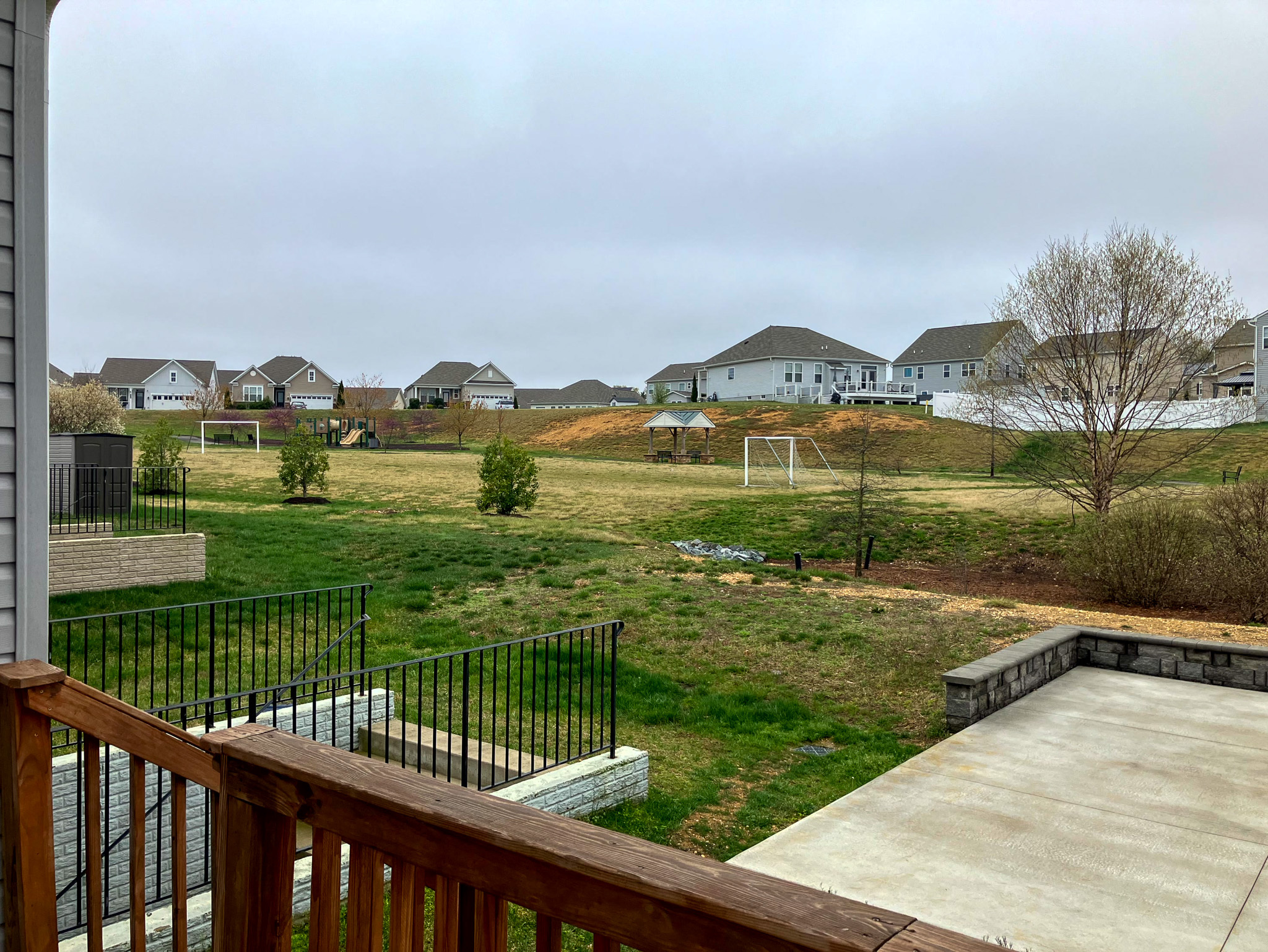 A view from a deck overlooking a grassy backyard that opens to a large common area with scattered houses in the distance outside the home of Sponsored Residential Providers Torwon and Deljuan Mitchell in Fredericksburg, Virginia.