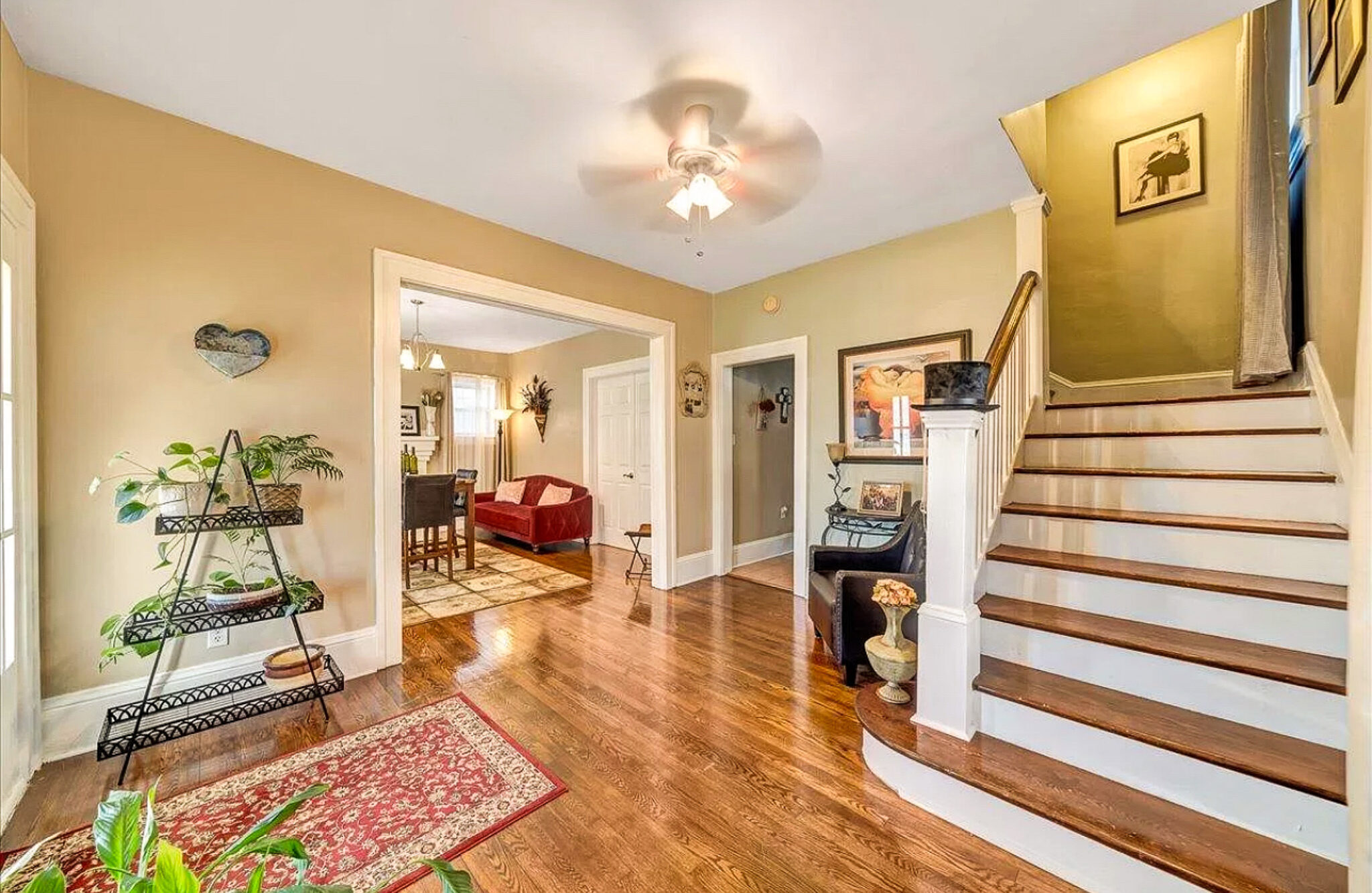 A bright entryway with wooden floors, a staircase to the right, and open doorways leading to adjacent rooms inside the home of Sponsored Residential Provider Jessica Peregrino in Roanoke, Virginia.