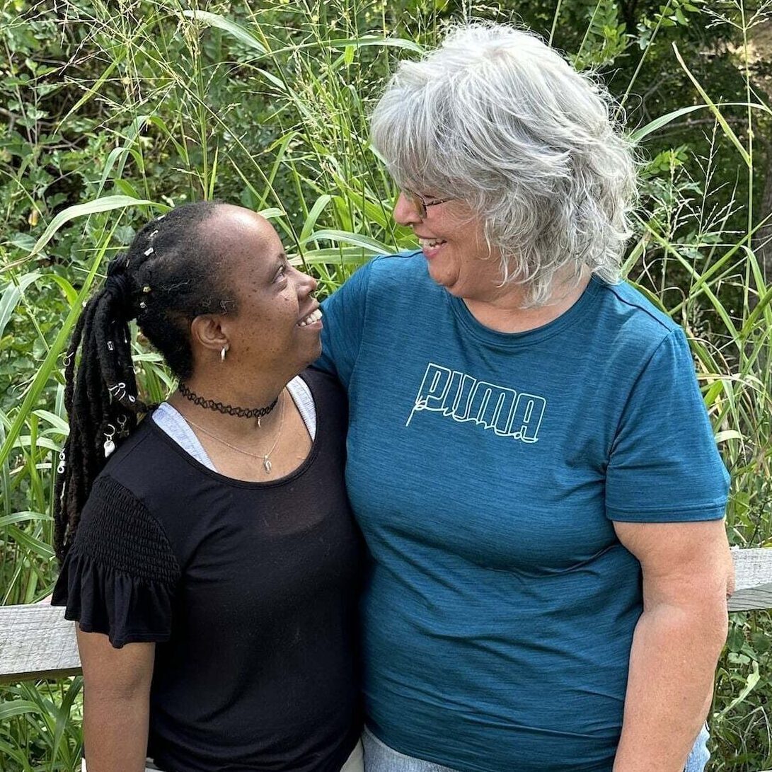 An individual and a provider side by side smiling at each other