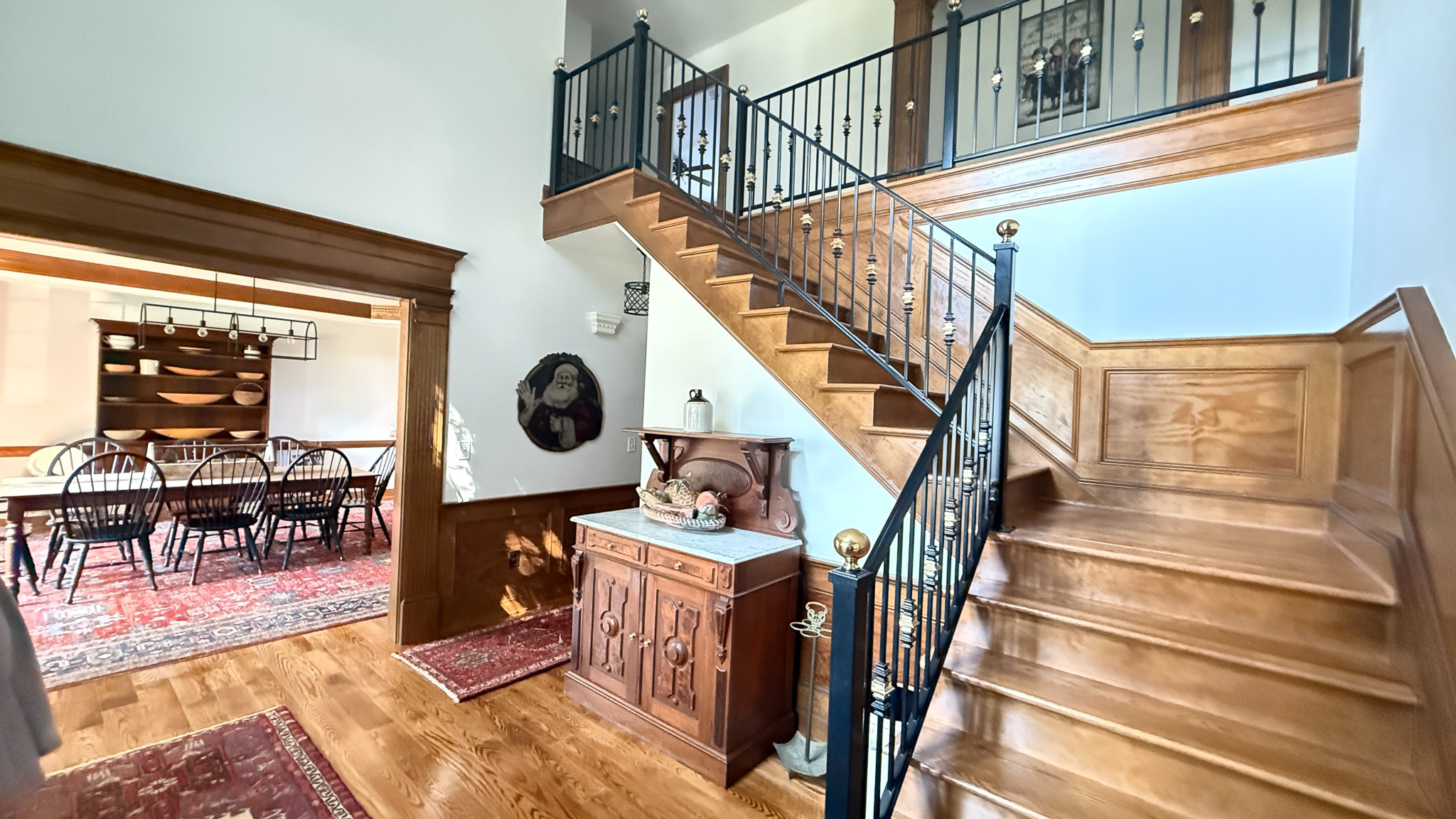 Entryway with staircase, wood paneling, and adjacent dining room visible through a doorway inside the home of Group home providers Rhonda and Bruce Norconk in Lynchburg, VA.