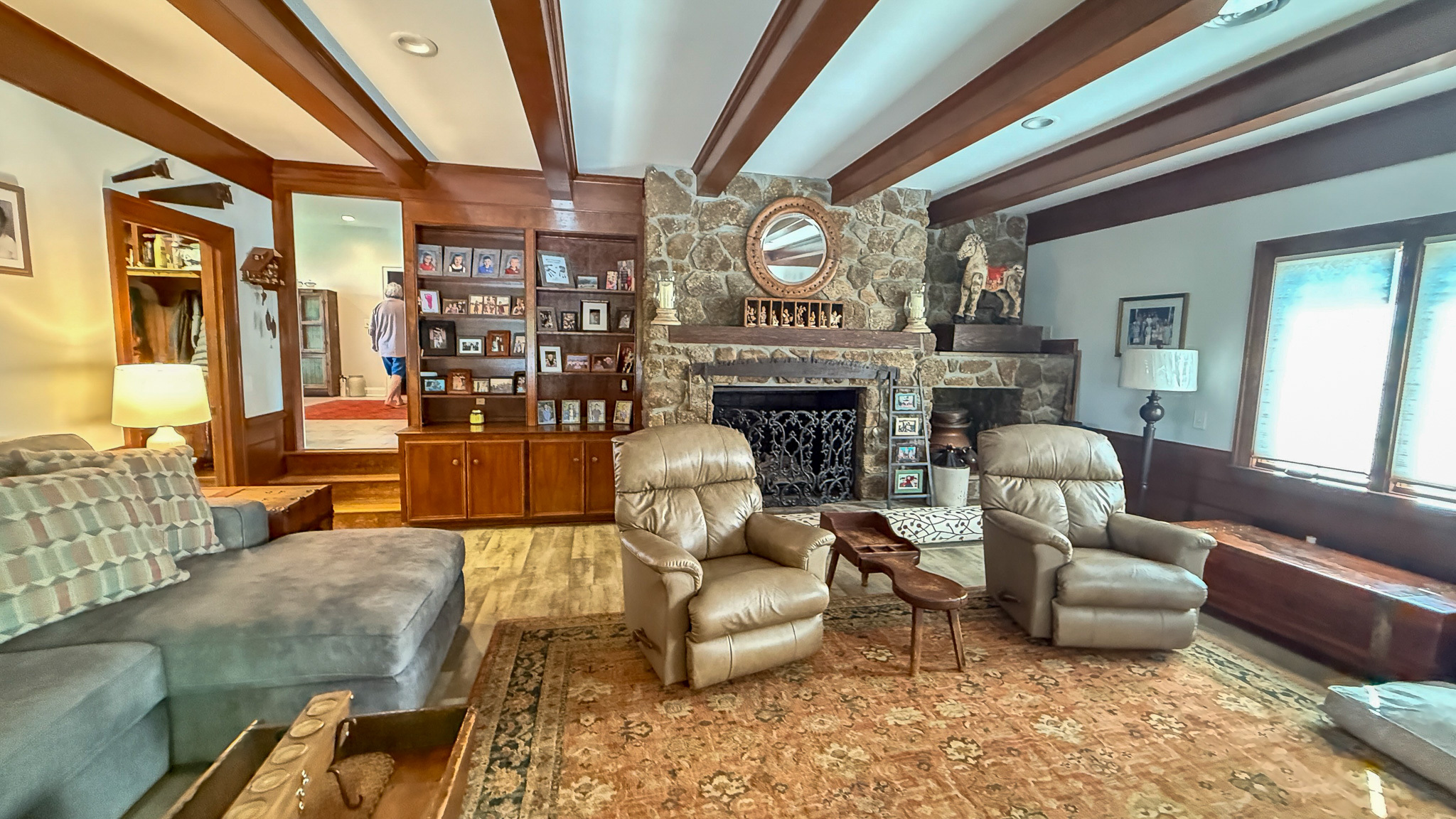 Living room with stone fireplace, built-in shelving, and multiple recliners inside the home of Group home providers Rhonda and Bruce Norconk in Lynchburg, VA.
