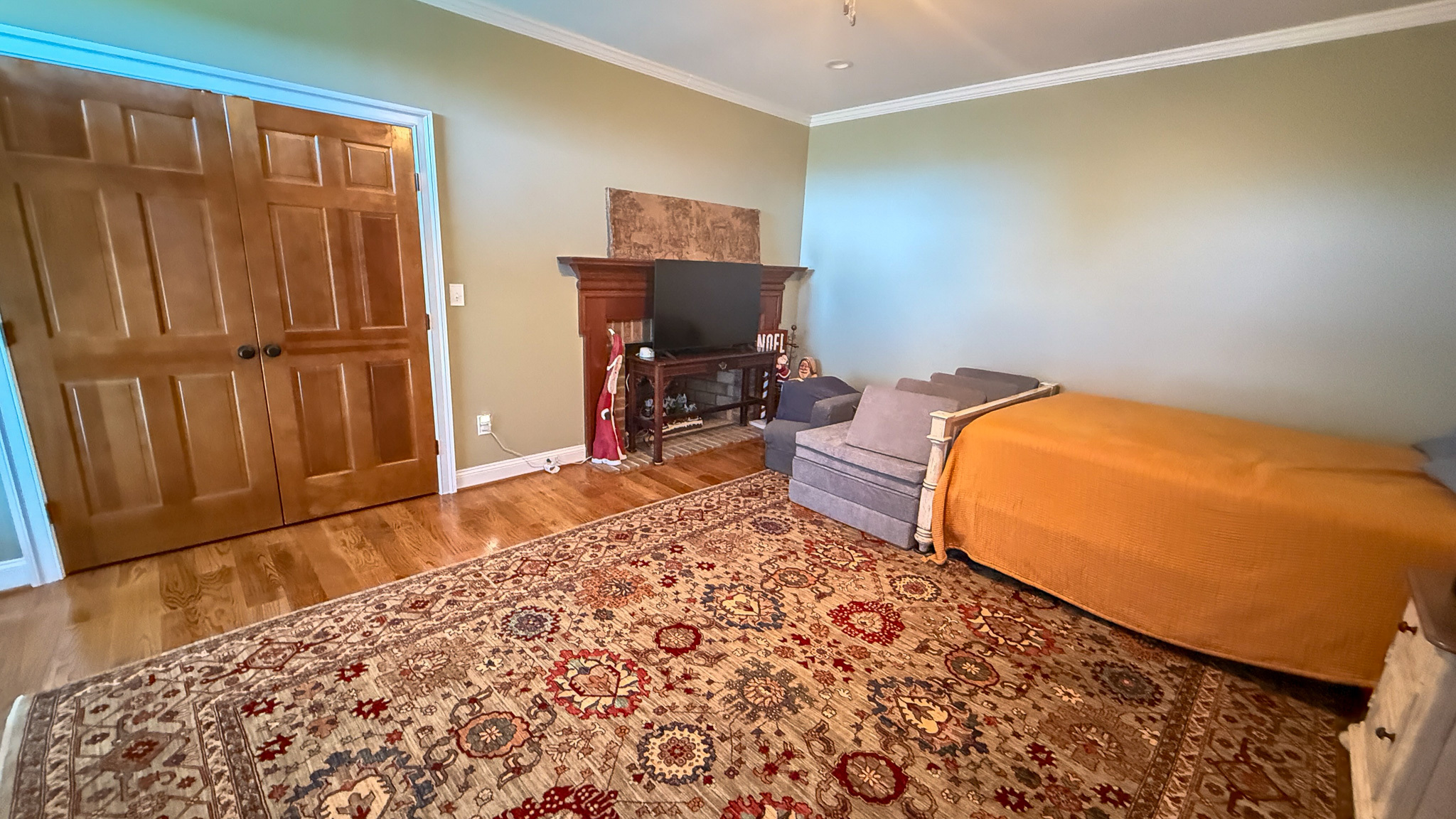 Cozy sitting area with a bed, chairs, and a patterned rug inside the home of Group home providers Rhonda and Bruce Norconk in Lynchburg, VA.
