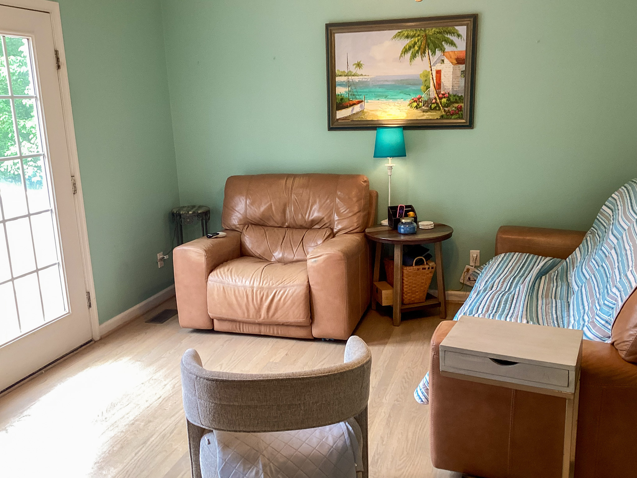 Inviting living area with comfortable seating, soft lighting, and a peaceful view through glass doors, in the home of Sponsored Residential Provider Roxane Barnes.