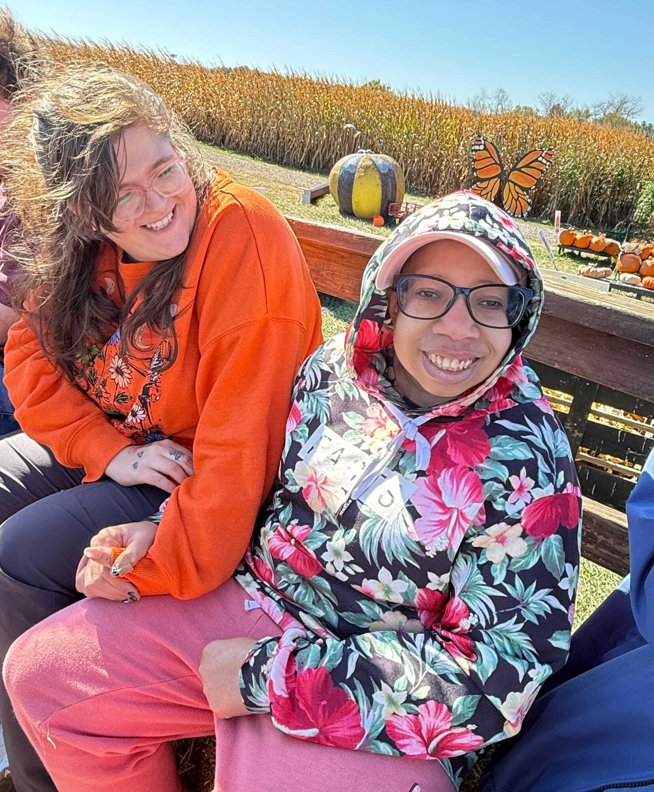 Two women enjoying a hayride at a pumpkin patch
