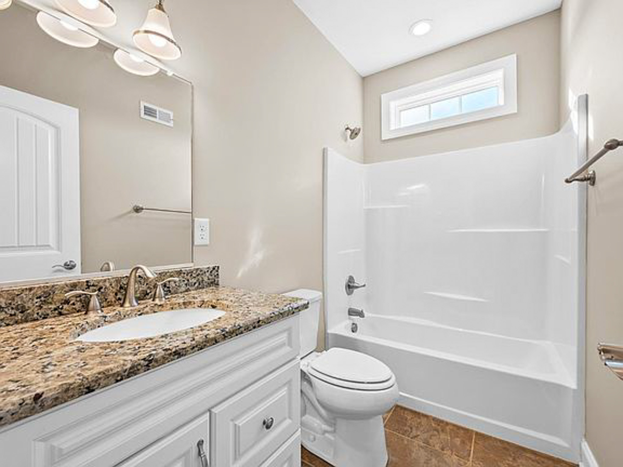 Bathroom with granite‑top vanity, white cabinets, and a white tub‑shower combo, in the home of sponsored residential provider Lisa Reed in Lynchburg, Virginia.