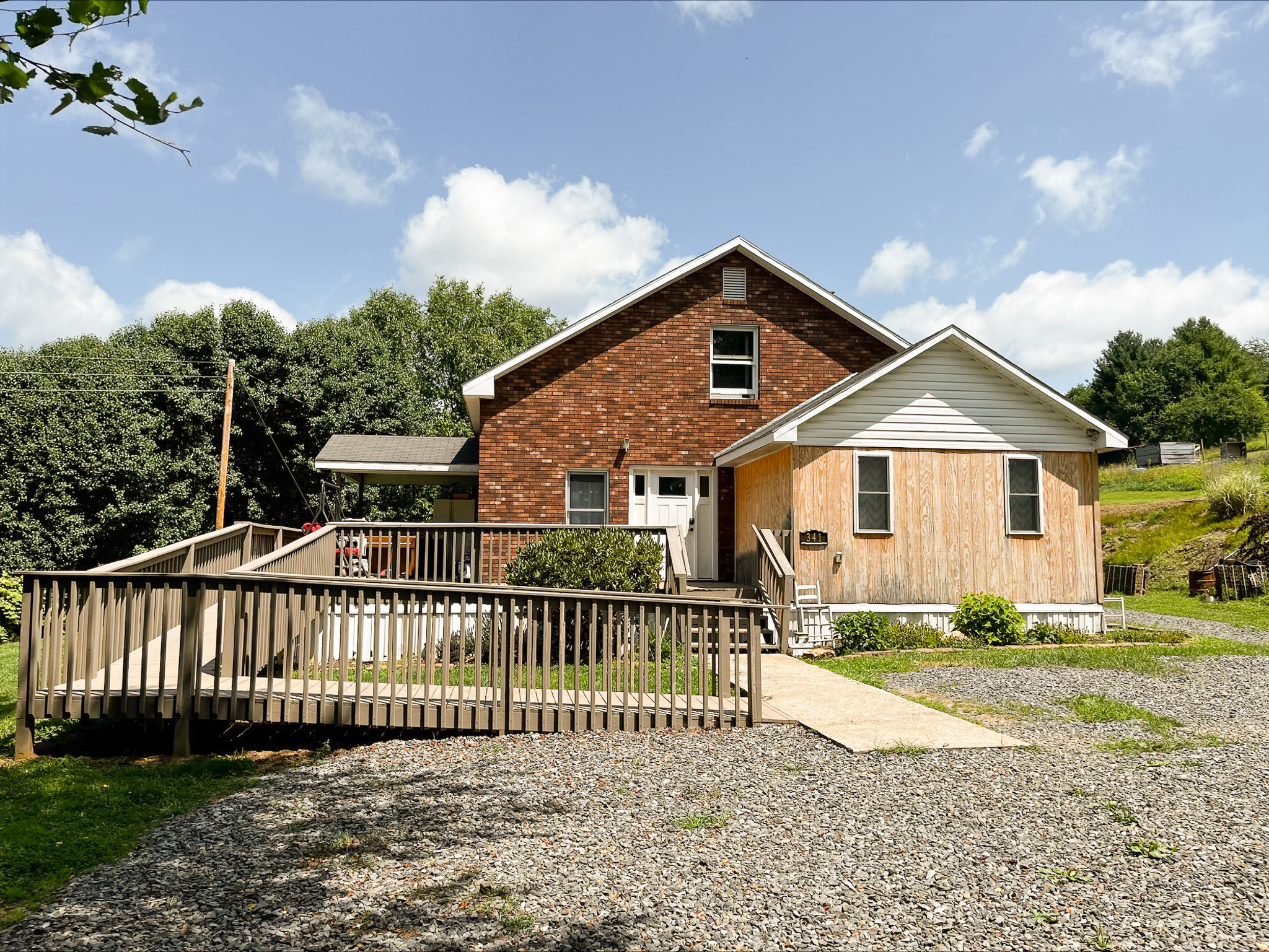 Single‑story house with mixed brick and light‑wood siding, a gravel driveway, and a wooden accessibility ramp belonging to Sponsored Residential Provider Dara Short in Willis, Virginia.