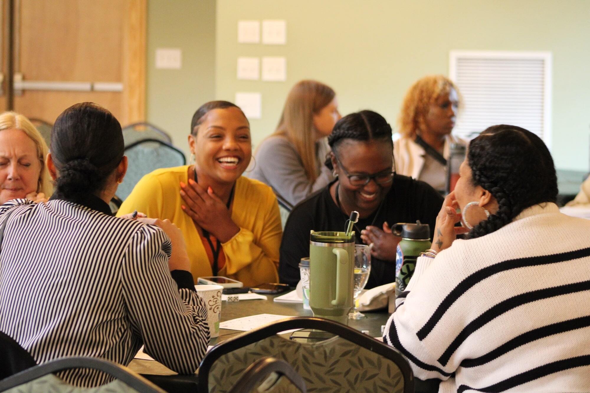 Group of Wall staff gathered around a table and laughing